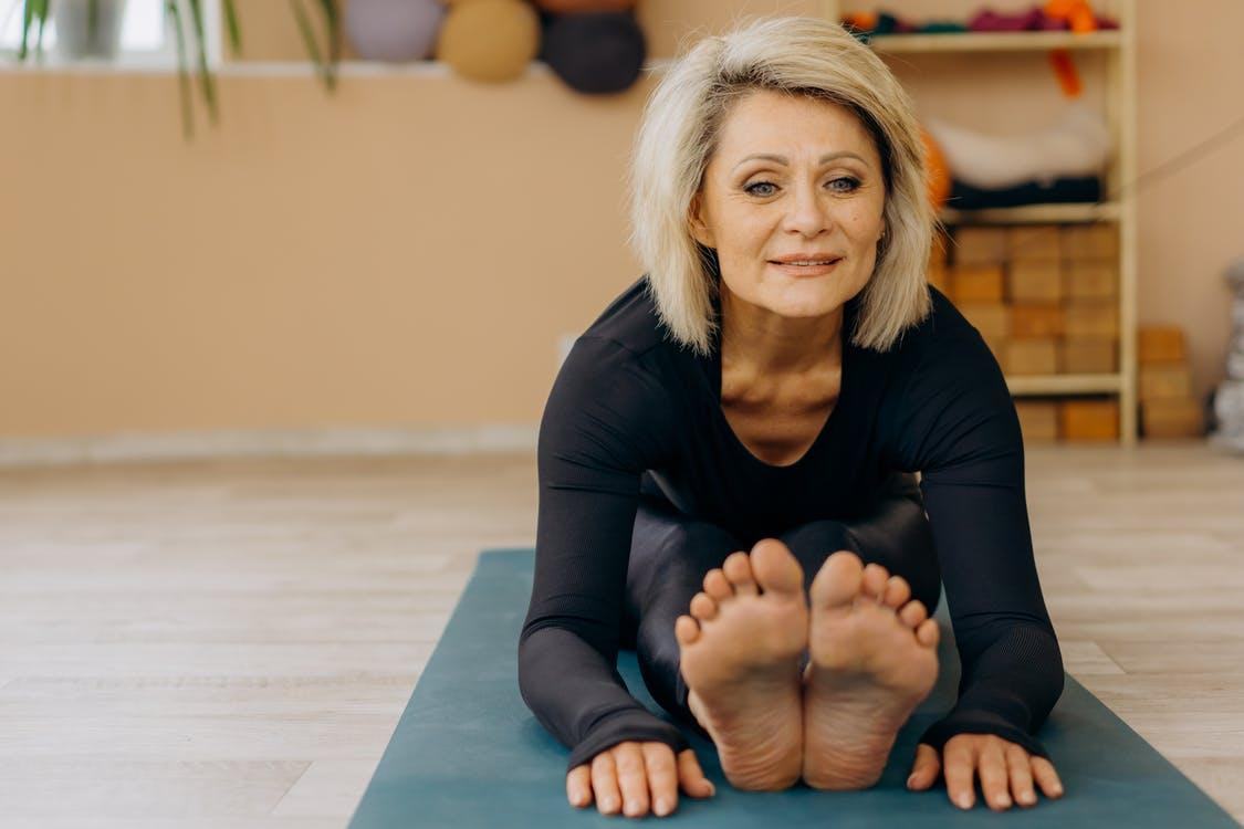 An elderly woman working out on a mat