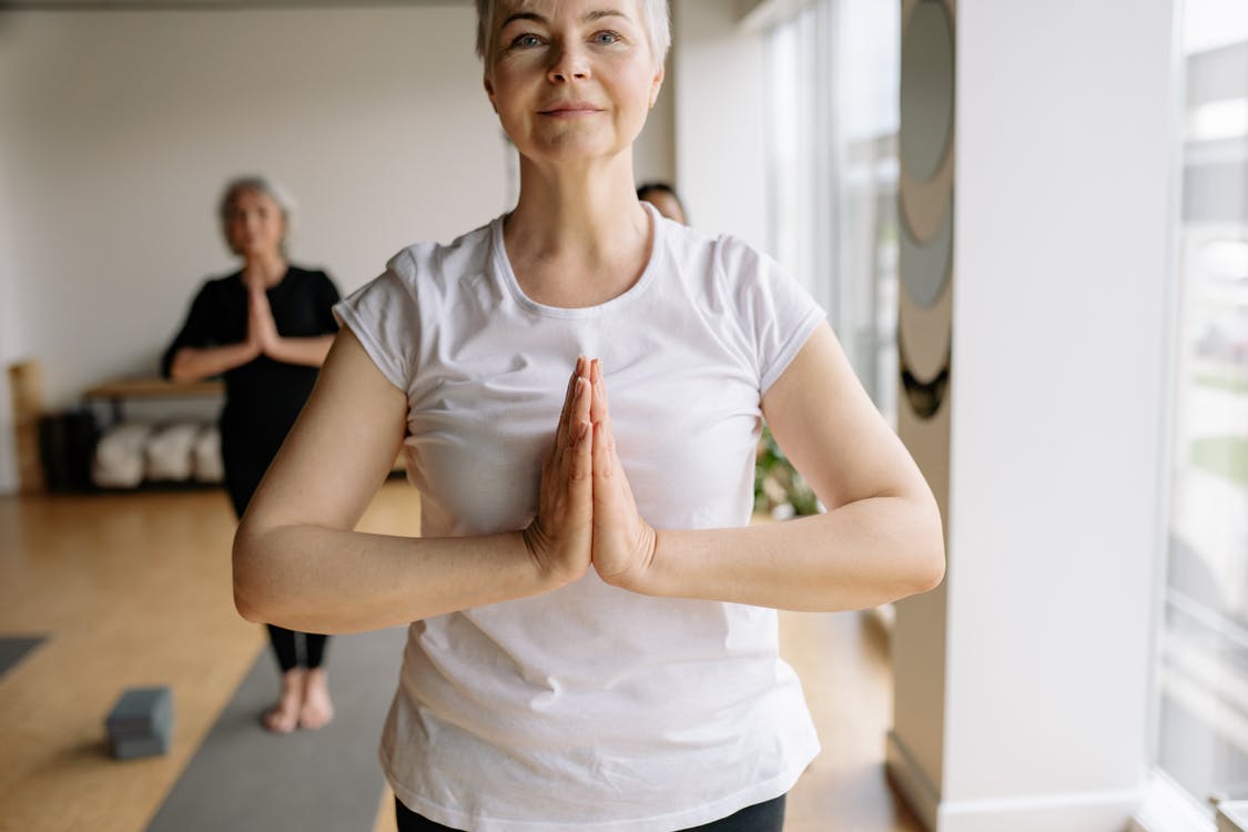 A woman doing yoga in a white shirt